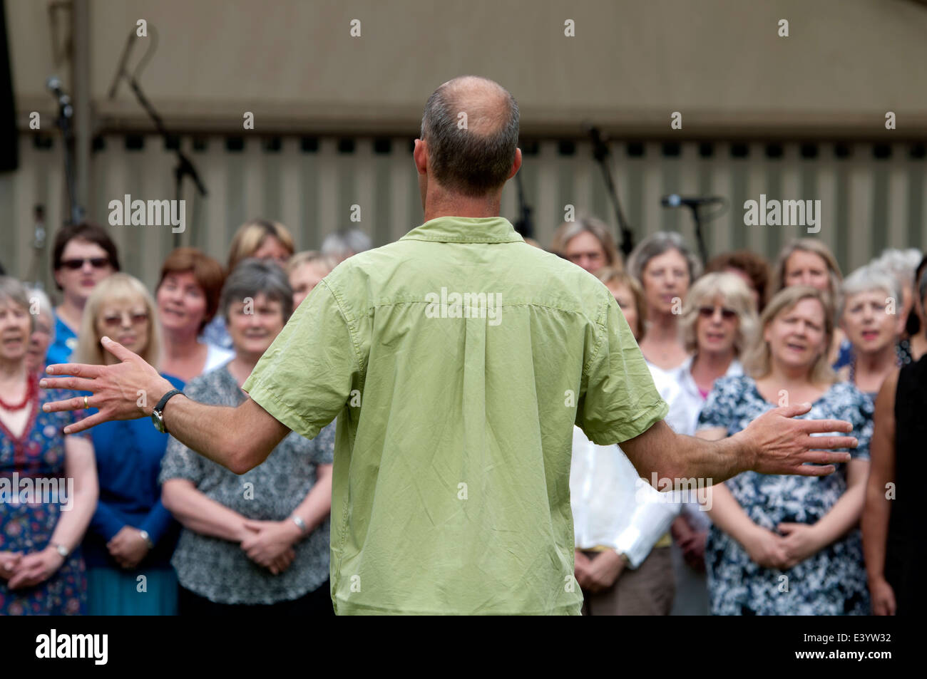 Ein Mann führt einen Gemeinschaft-Chor bei Leamington Peace Festival, UK Stockfoto