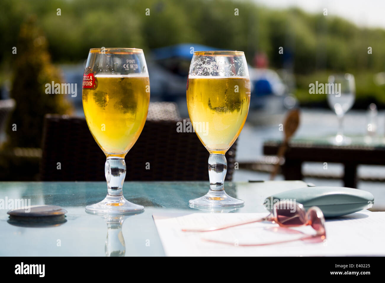 Genießen Sie ein kühles Pils im Biergarten. Sommer Urlaub Riverside Pub. Norfolk Broads England Großbritannien Stockfoto