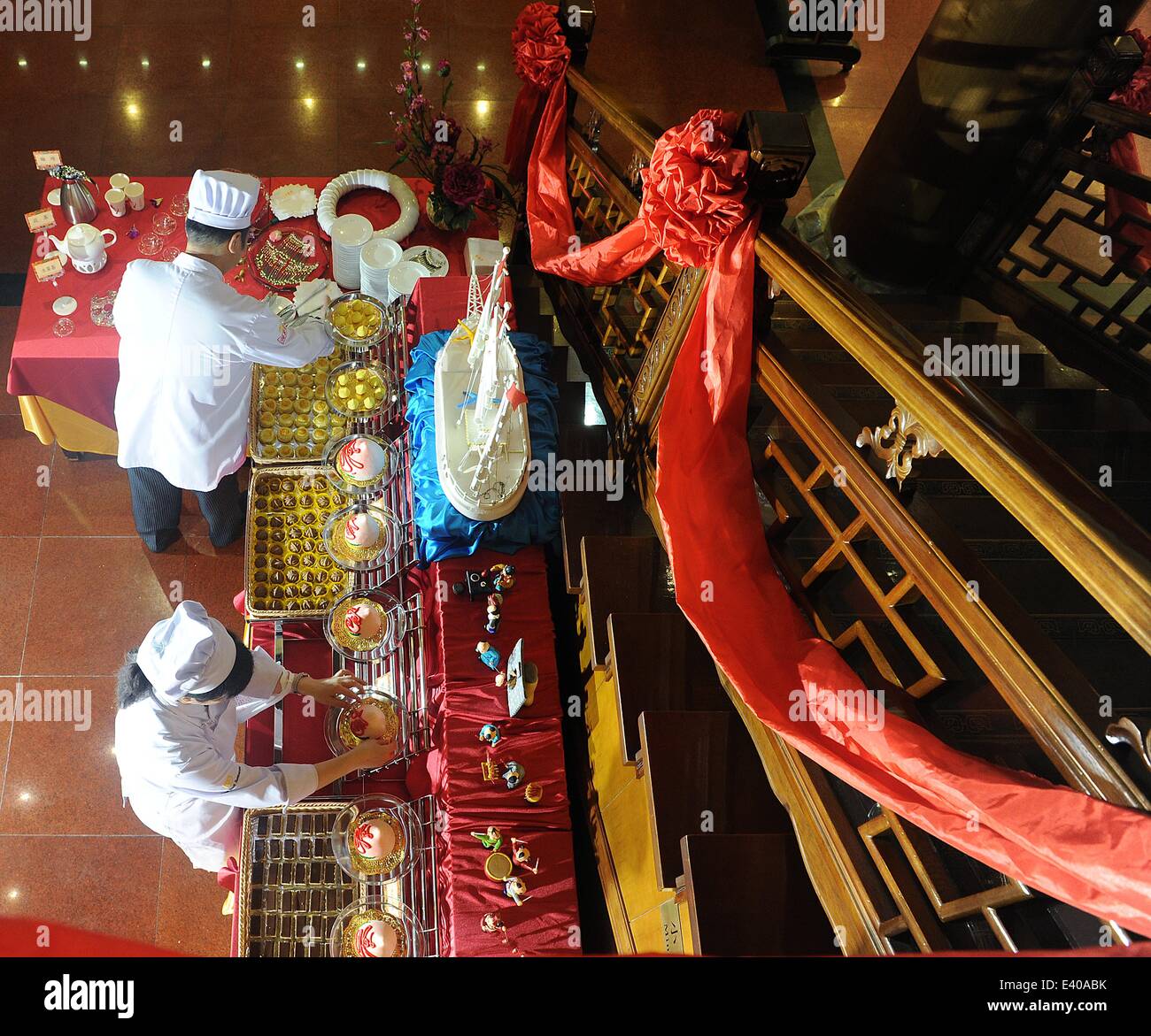 Peking, China. 2. Juli 2014. Mitarbeiter sind damit beschäftigt, Vermittlung von Schaufenster für eine Zeremonie für den 150. Jahrestag der Quanjude Peking Roast Duck Restaurant in seiner Qianmen-Niederlassung in Peking, Hauptstadt von China, 2. Juli 2014. Quanjude, das für seine langjährige kulinarische Heritge seit seiner Gründung im Jahre 1864 in seiner Qianmen-Niederlassung in Peking bekannt ist, erhielt ihr 150-jähriges bestehen und eine Zeremonie anlässlich seiner 196 Millonth gebratene Ente war auch hier statt. Bildnachweis: Zhang Yan/Xinhua/Alamy Live-Nachrichten Stockfoto