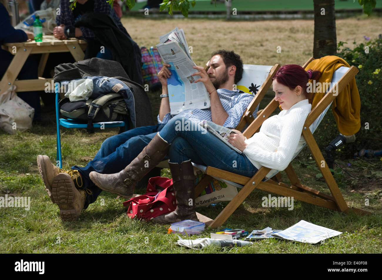 Mann & Frau sitzen in Liegestühlen lesen Zeitungen bei Hay Festival 2014 © Jeff Morgan Stockfoto