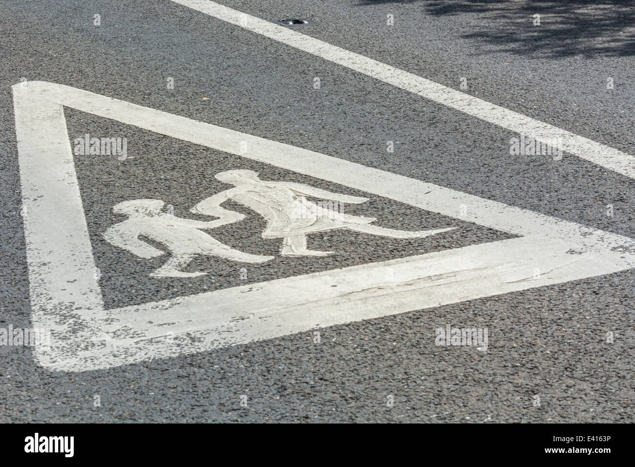 Schild mit der Schulwarnung auf der Straße, auf dem das Piktogramm des Mädchens und Jungen zu Fuß zum Piktogramm der Schule zu sehen ist. Metapher Rückkehr zur Schule, neuer Begriff, Begriff beginnt. Stockfoto