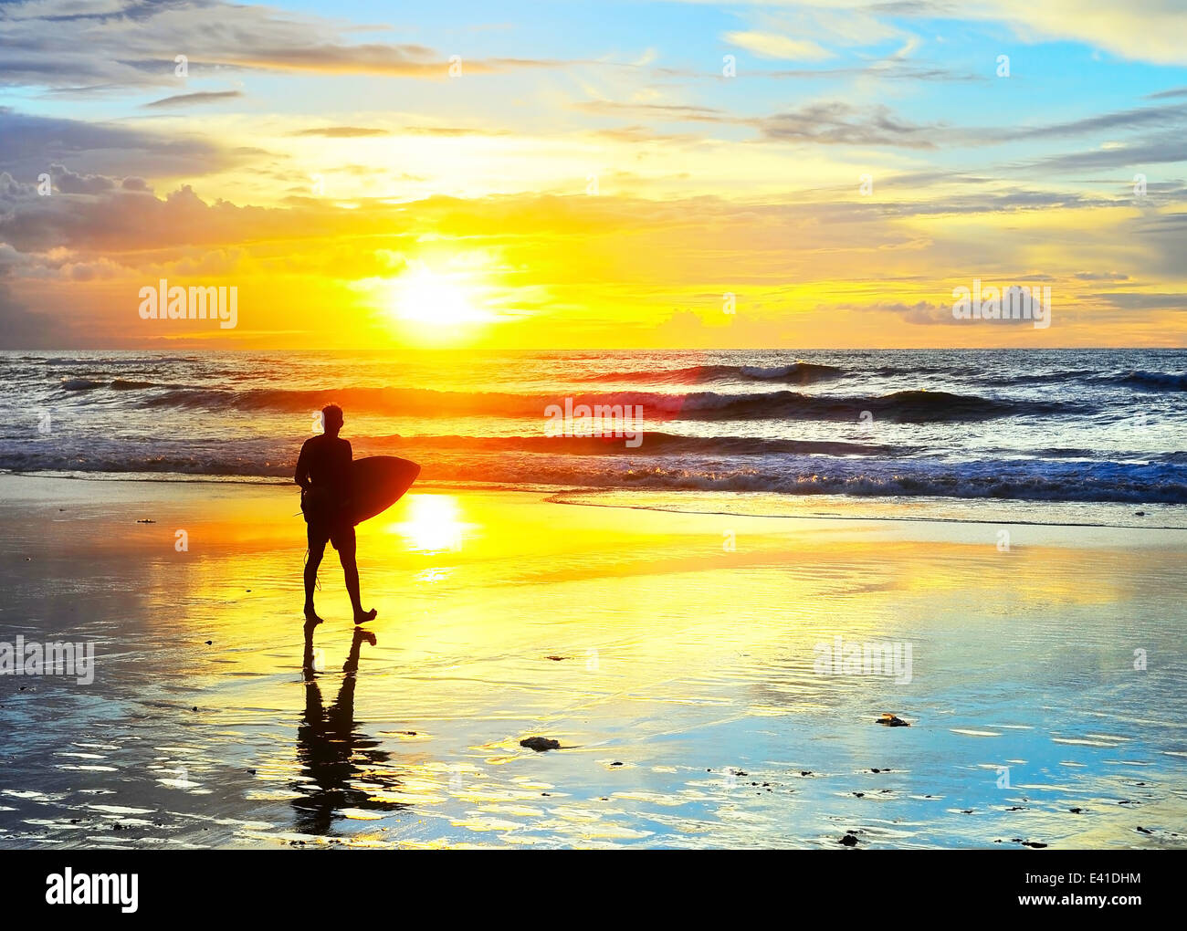 Surfer mit Surfbrett zu Fuß am Meer Strand bei Sonnenuntergang. Insel Bali, Indonesien Stockfoto