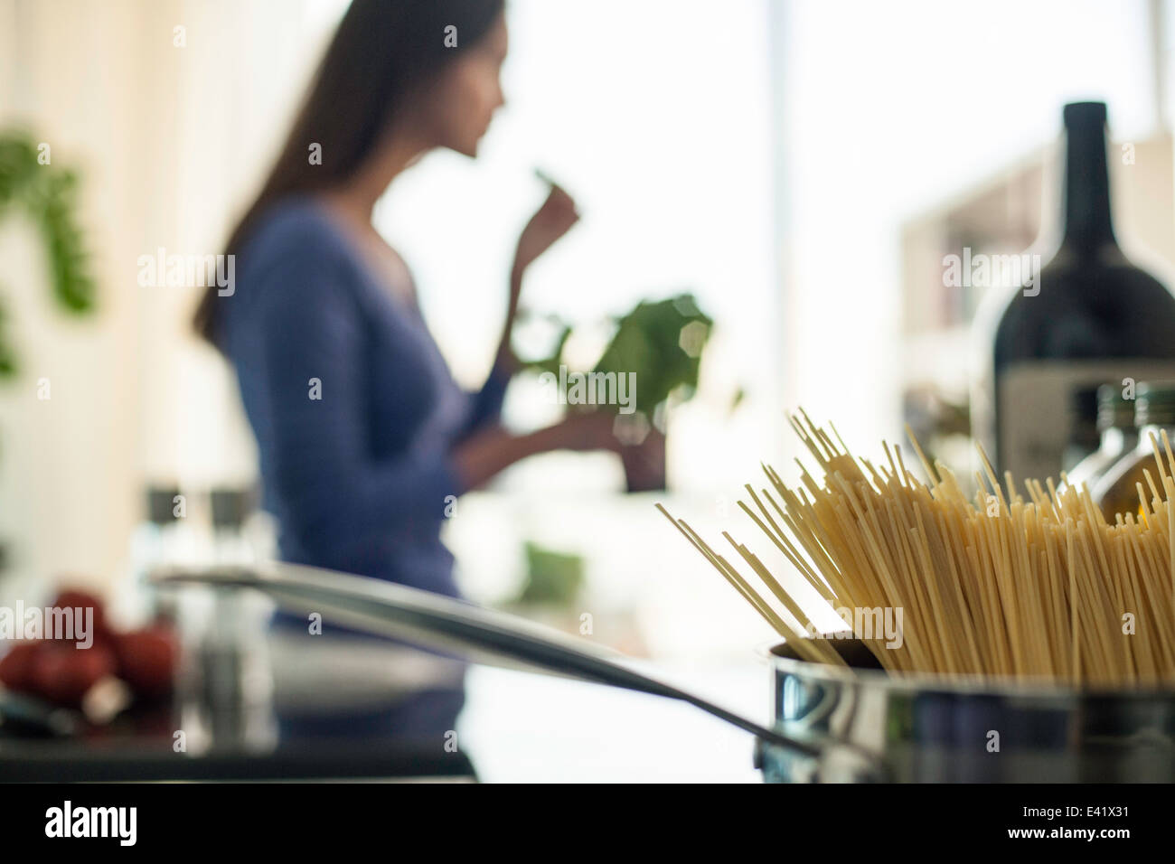 Verschwommenes Bild der jungen Frau, die Zubereitung von Speisen in der Küche Stockfoto