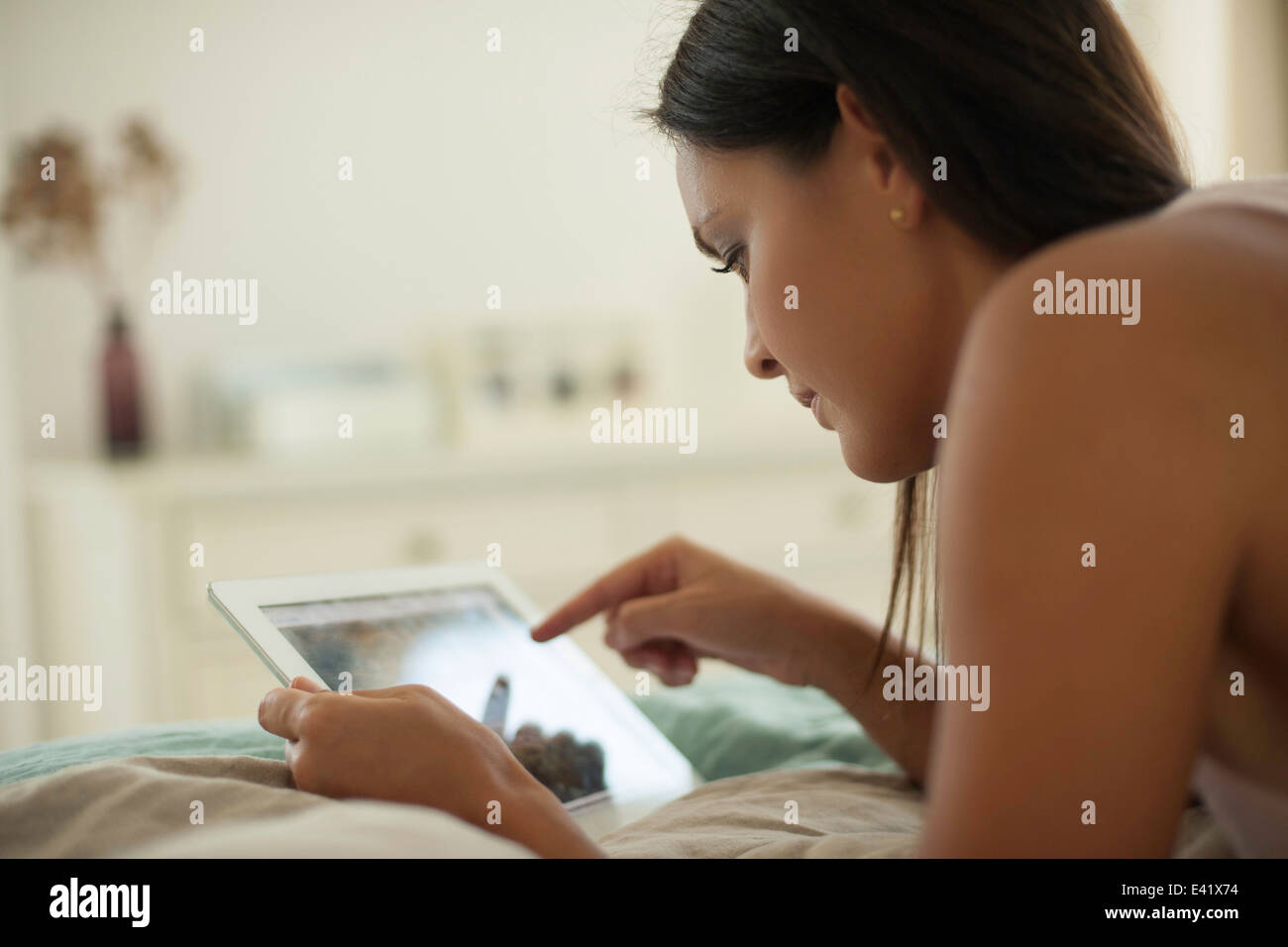 Junge Frau auf Bett mit digital-Tablette Stockfoto