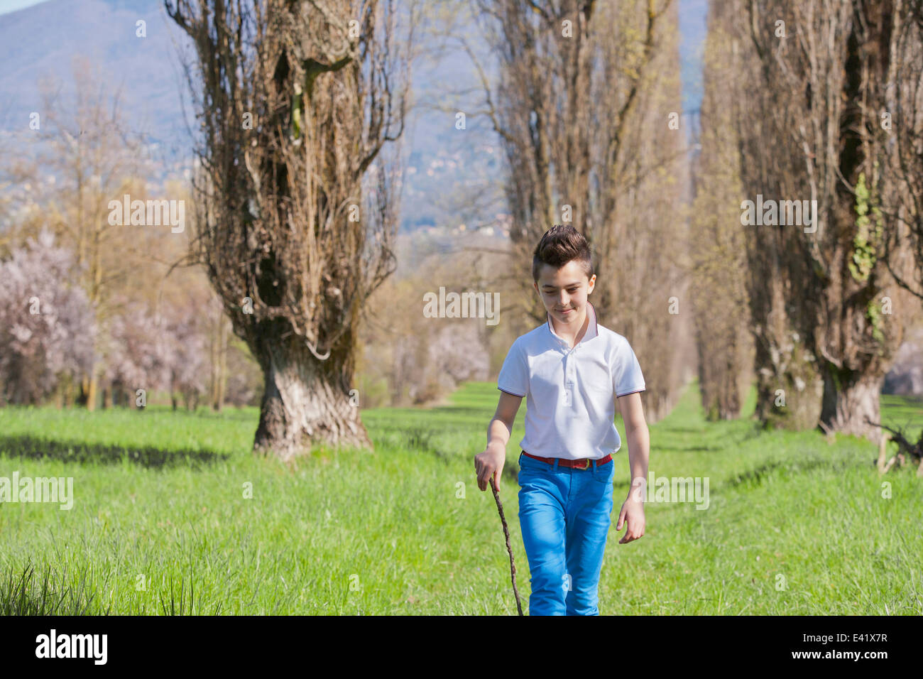 Zwölf Jahre alter Junge, ein Spaziergang mit Gehstock Stockfoto