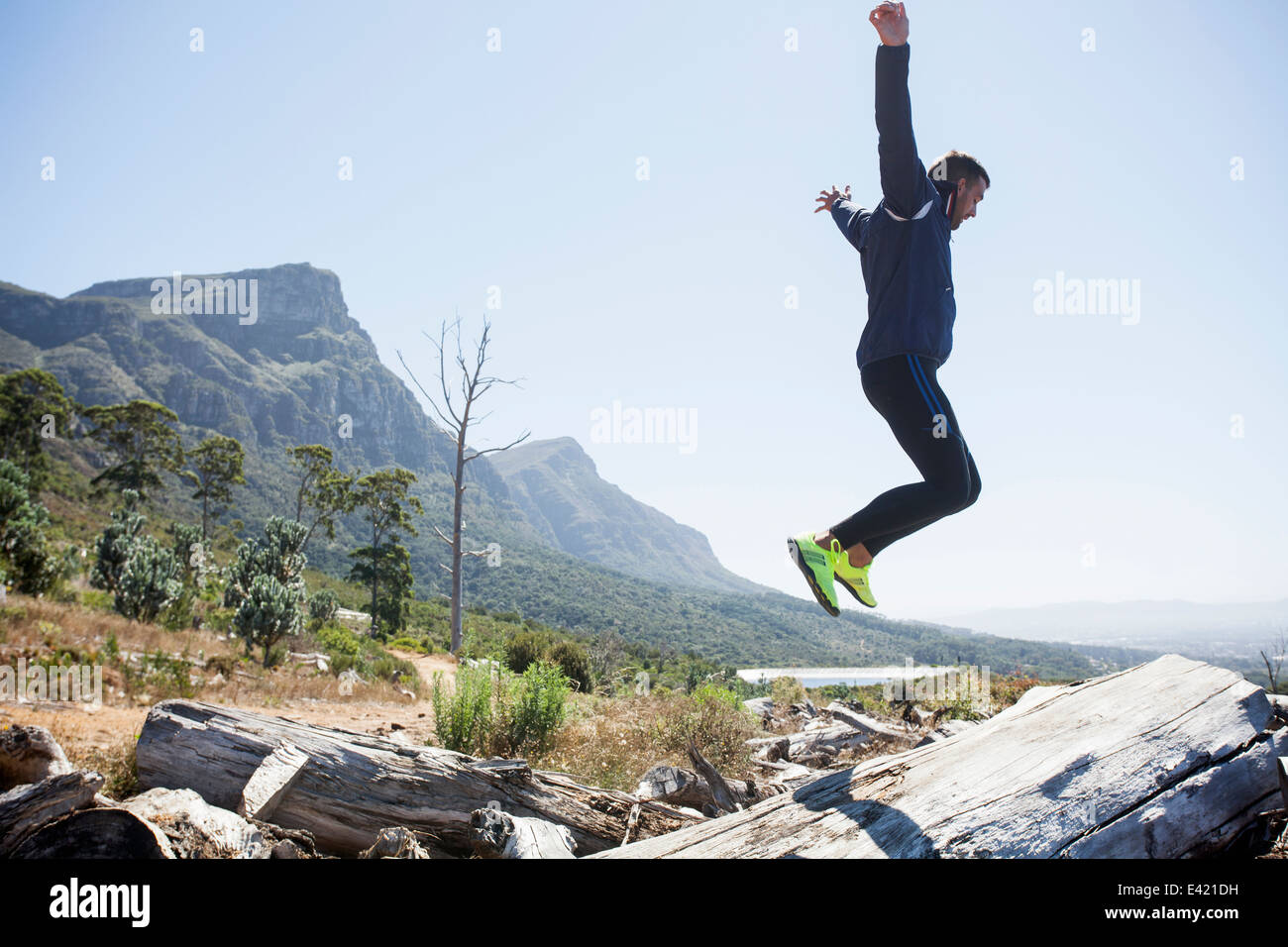 Männliche Jogger springen in der Luft Stockfoto