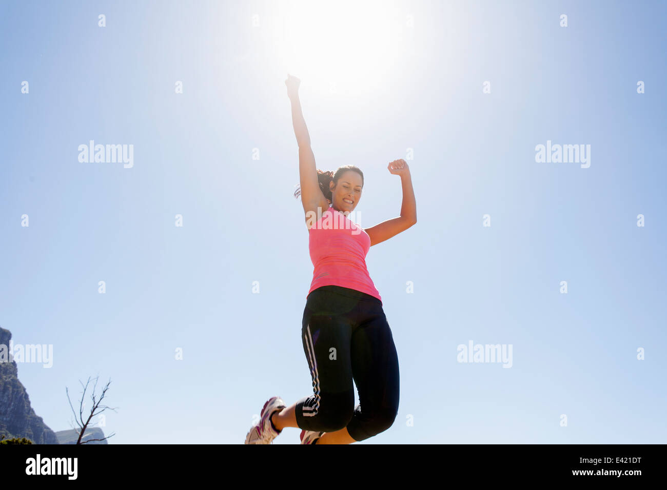 Weibliche Jogger springen in der Luft Stockfoto