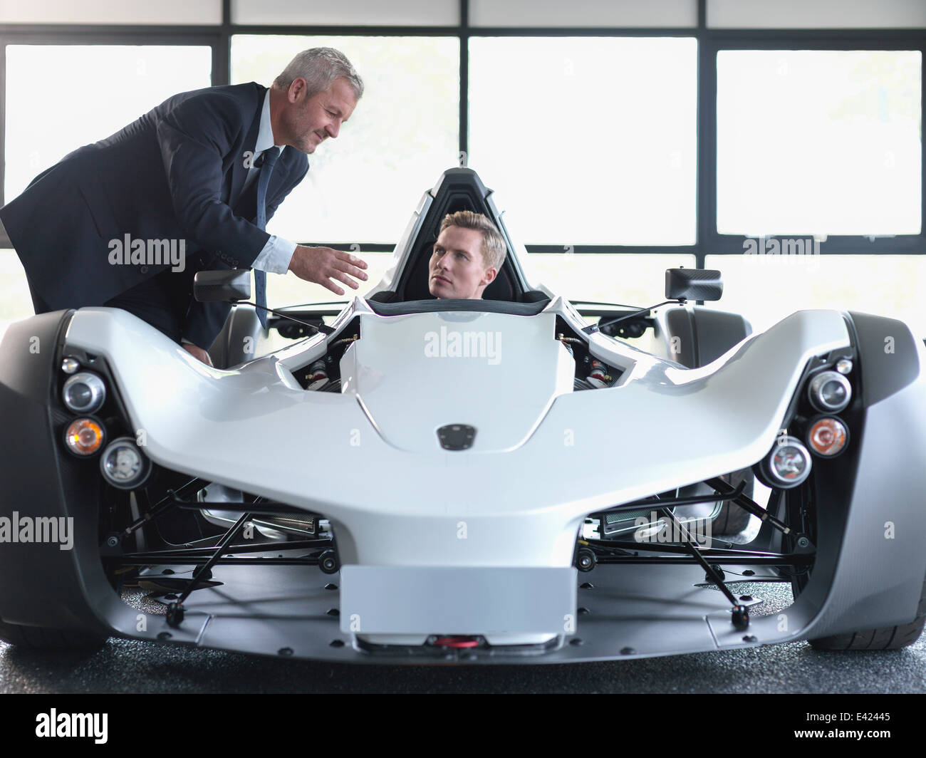 Verkäufer mit Kunden Supersportwagen im Show-room Stockfoto