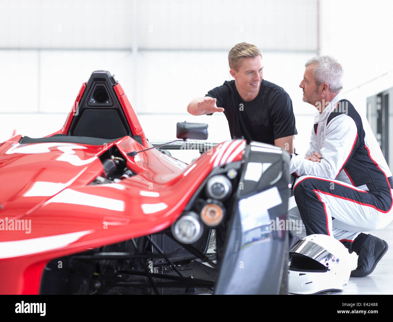 Racing Car Fahrer und Ingenieur mit Supersportwagen Sportwagen Fabrik Stockfoto