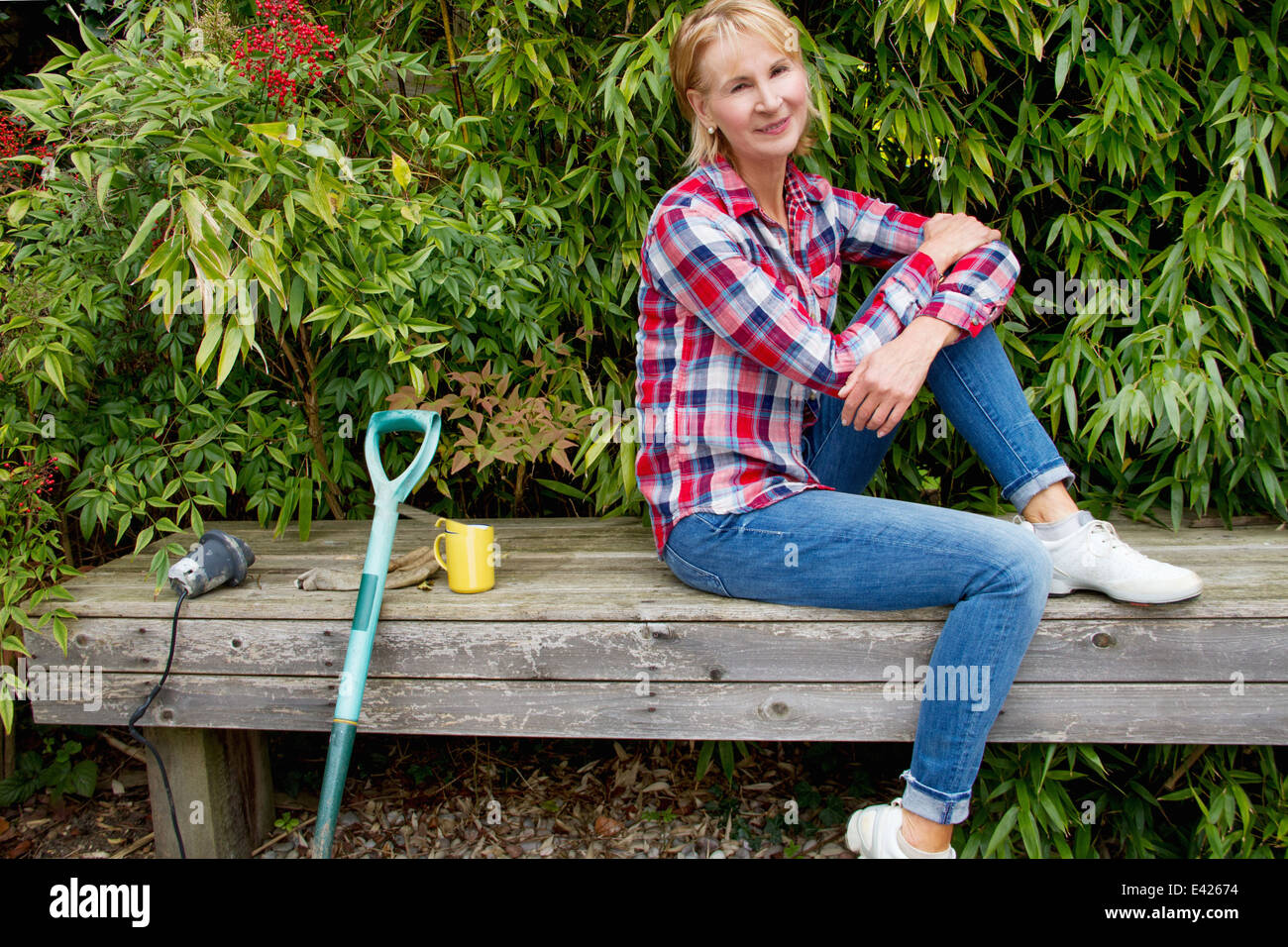 Porträt von Reife Frau eine Pause auf Gartenbank Stockfoto