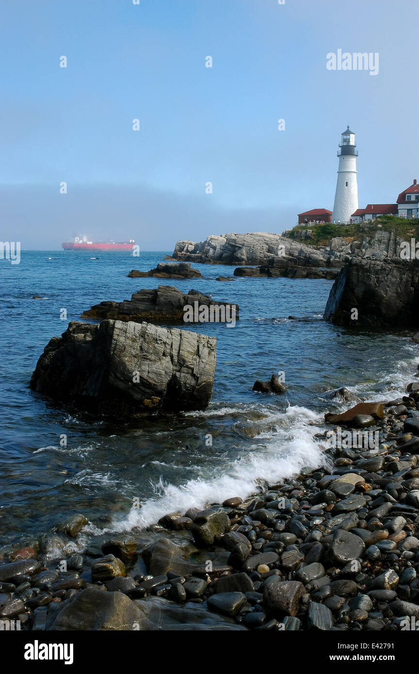 Portland Leuchtturm Reiseführer roten Tanker Schiff entlang der felsigen Küste durch Nebel aus Portland Harbour auf Casco Bay in Maine. Stockfoto