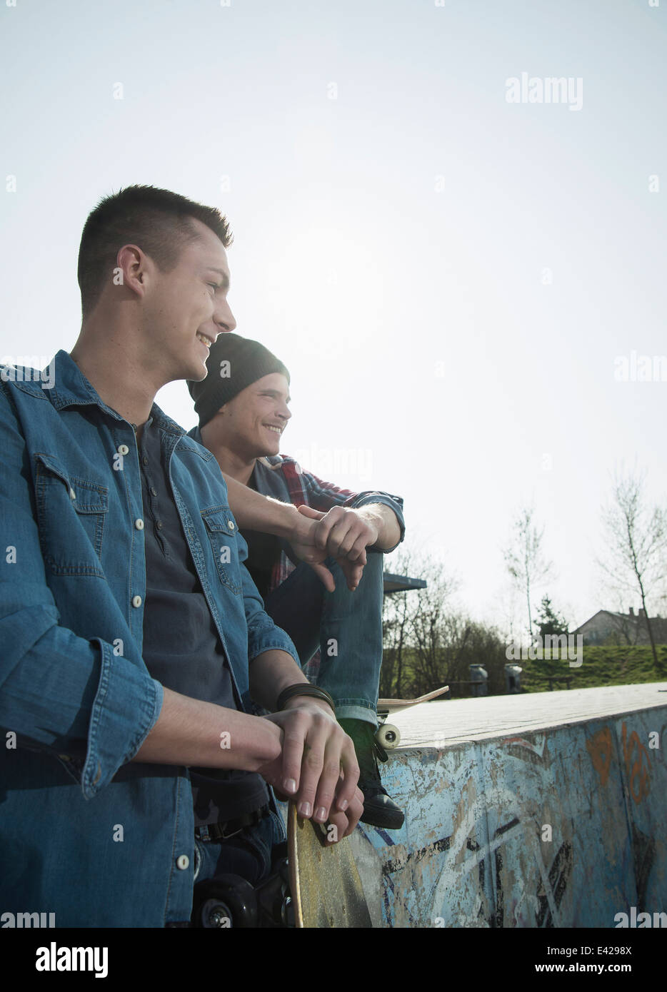 Junge Männer sitzen zusammen im skatepark Stockfoto