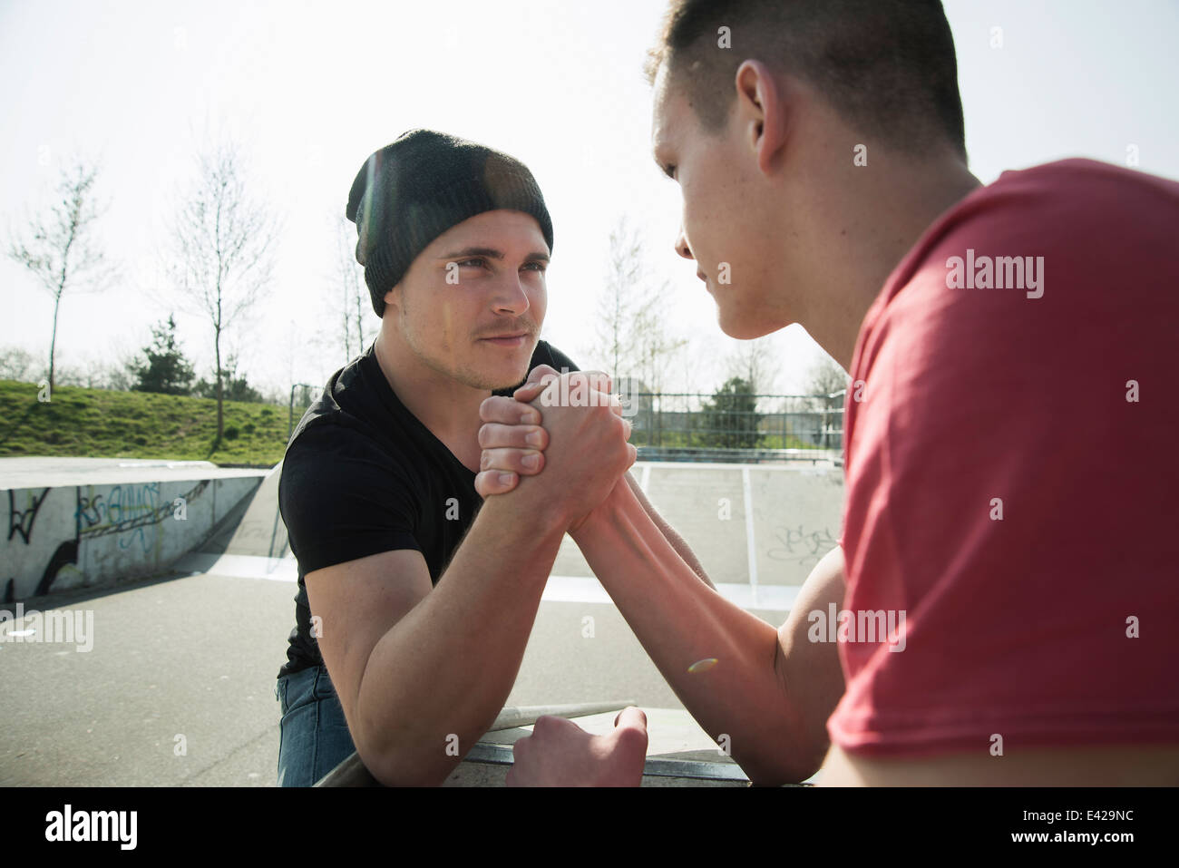 Junge Männer im Skatepark Armdrücken Stockfoto