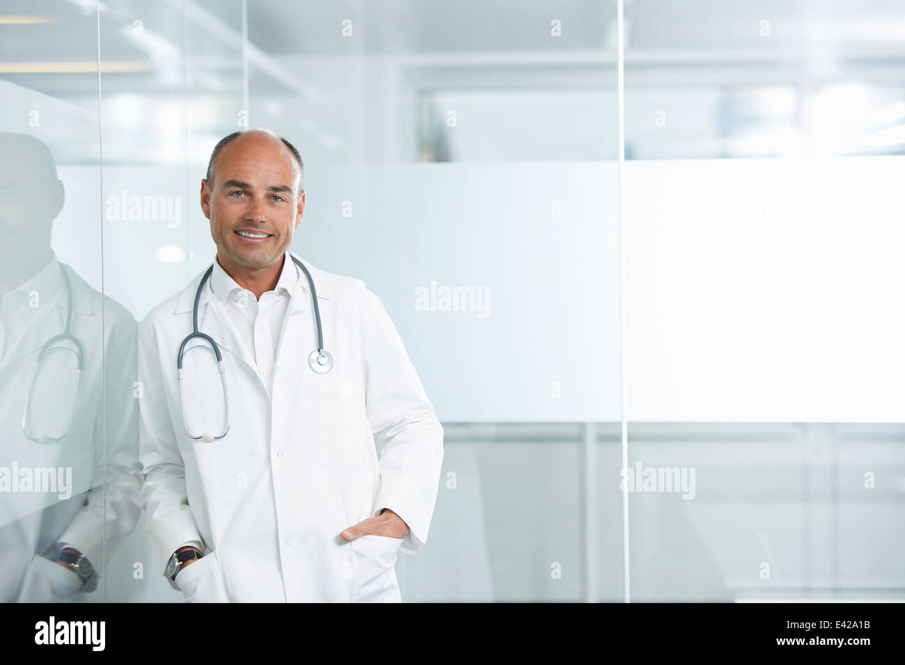 Männlichen Arzt reflektierenden Wand gelehnt Stockfoto
