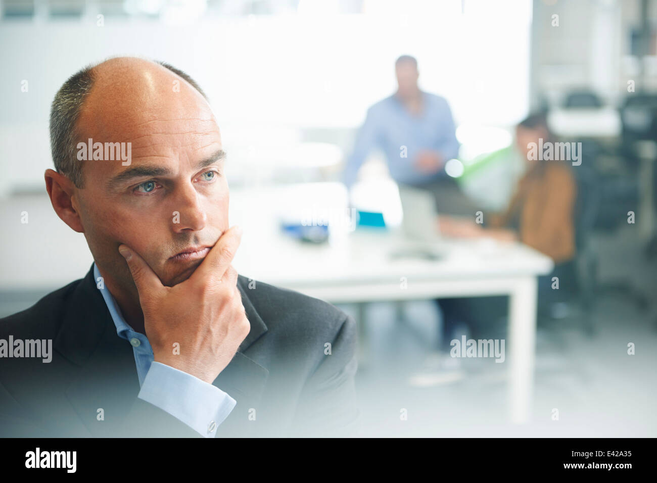 Mann denkt, Menschen im Hintergrund Stockfoto