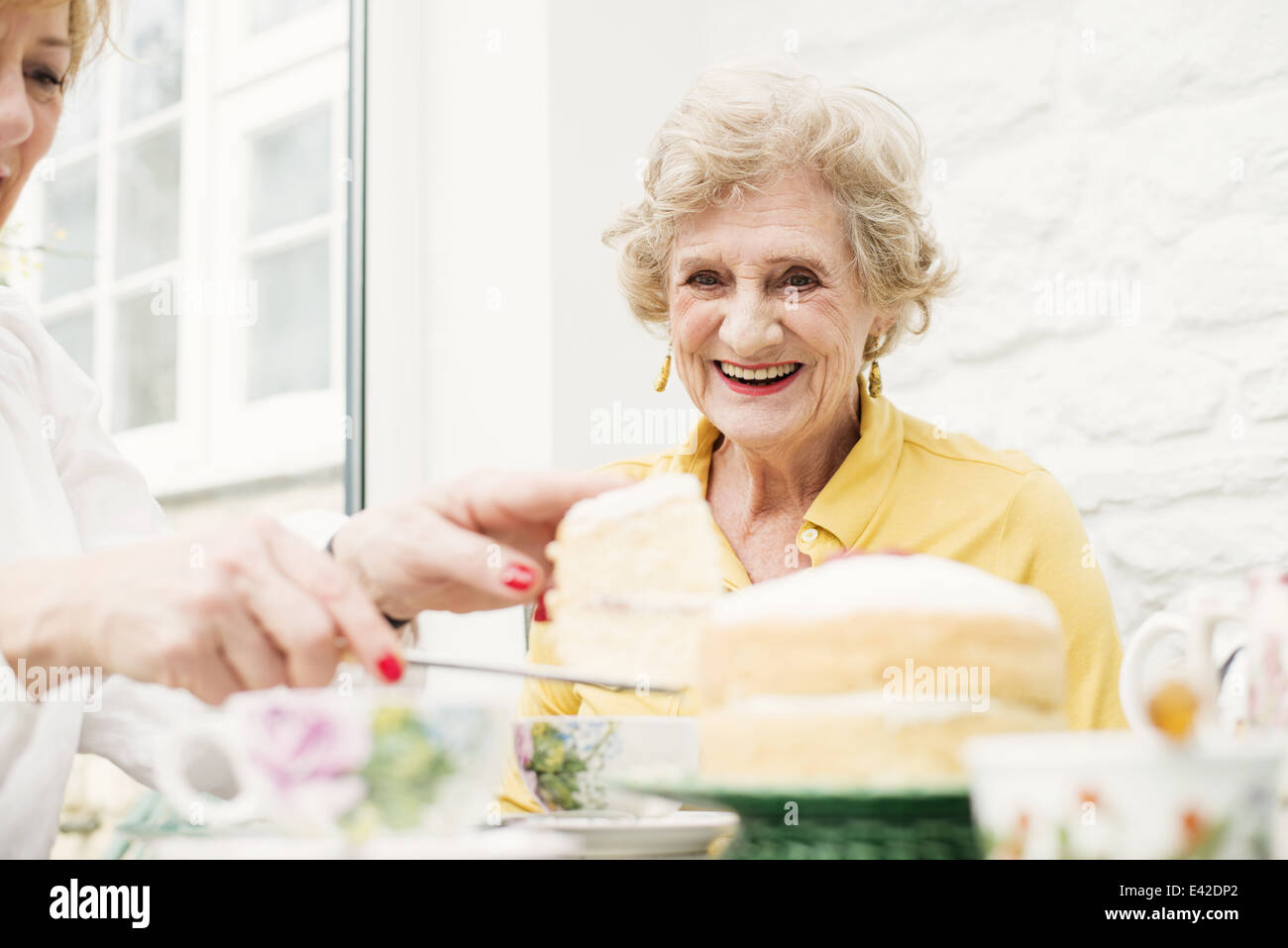 Ältere Frau und Tochter, Kuchen schneiden Stockfoto