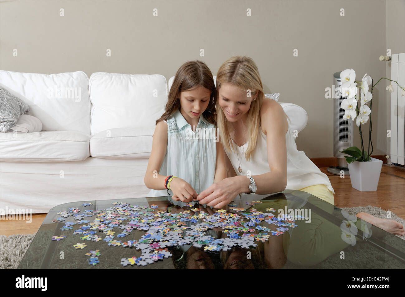 Mutter und Tochter tut Jigsaw puzzle auf Couchtisch Stockfoto