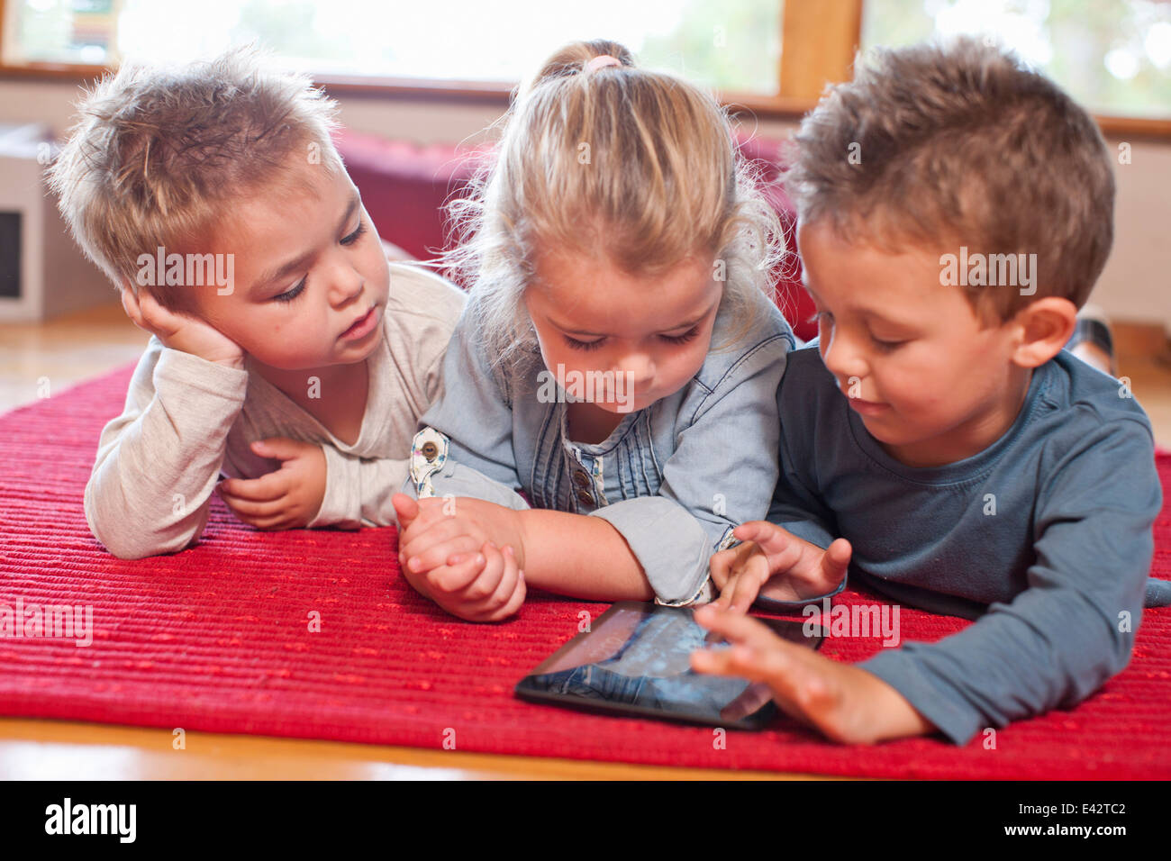 Zwei Jungs und ein Mädchen mit digital-Tablette im Kindergarten Stockfoto