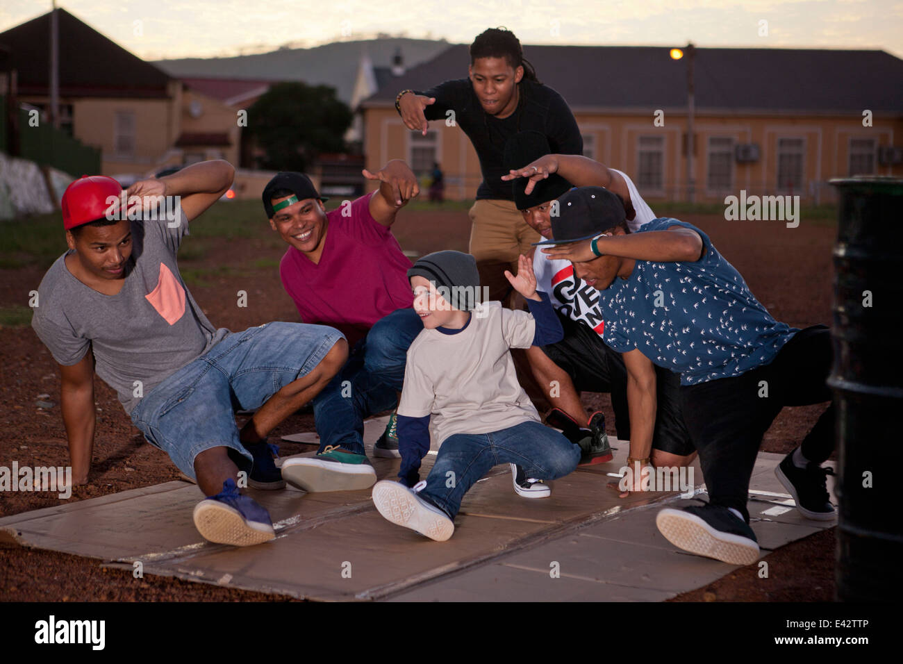 Gruppe von Erwachsenen Männern und jungen Breakdance im Park in der Abenddämmerung Stockfoto