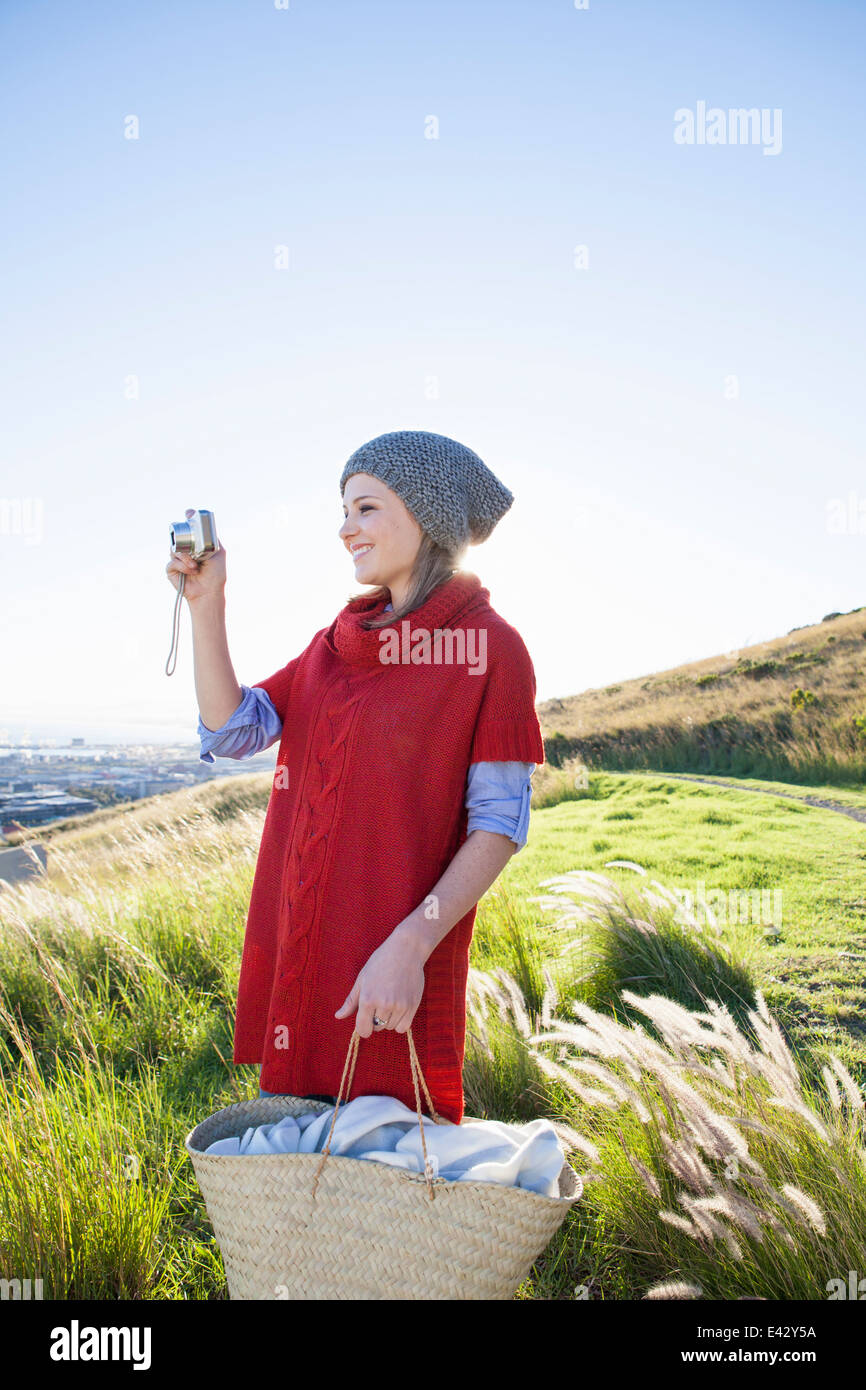 Junge Frau, die Aussicht vom Hügel zu fotografieren Stockfoto