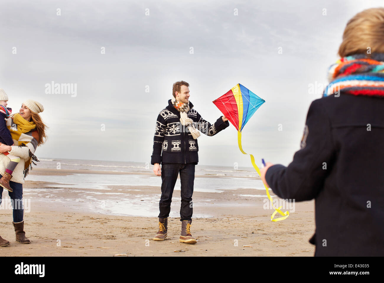 Mitte Erwachsenen Eltern mit Sohn und Tochter spielen mit Kite am Strand von Bloemendaal Aan Zee, Niederlande Stockfoto