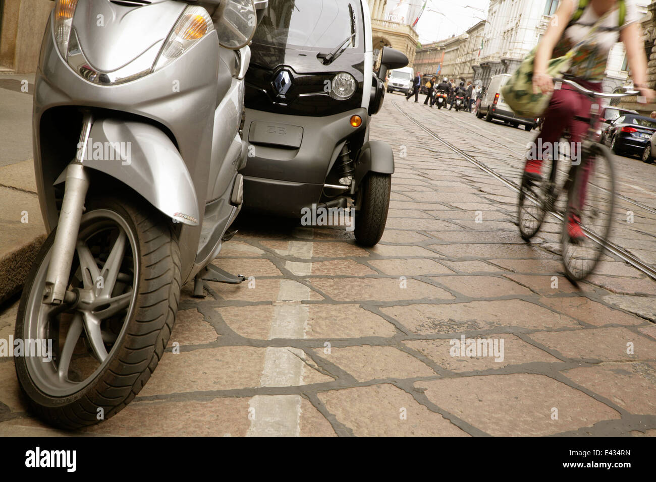 Radfahrer vorbei an Renault Twizy Elektro-Kleinwagen in der Nähe von La Scala, Mailand, Italien. Stockfoto