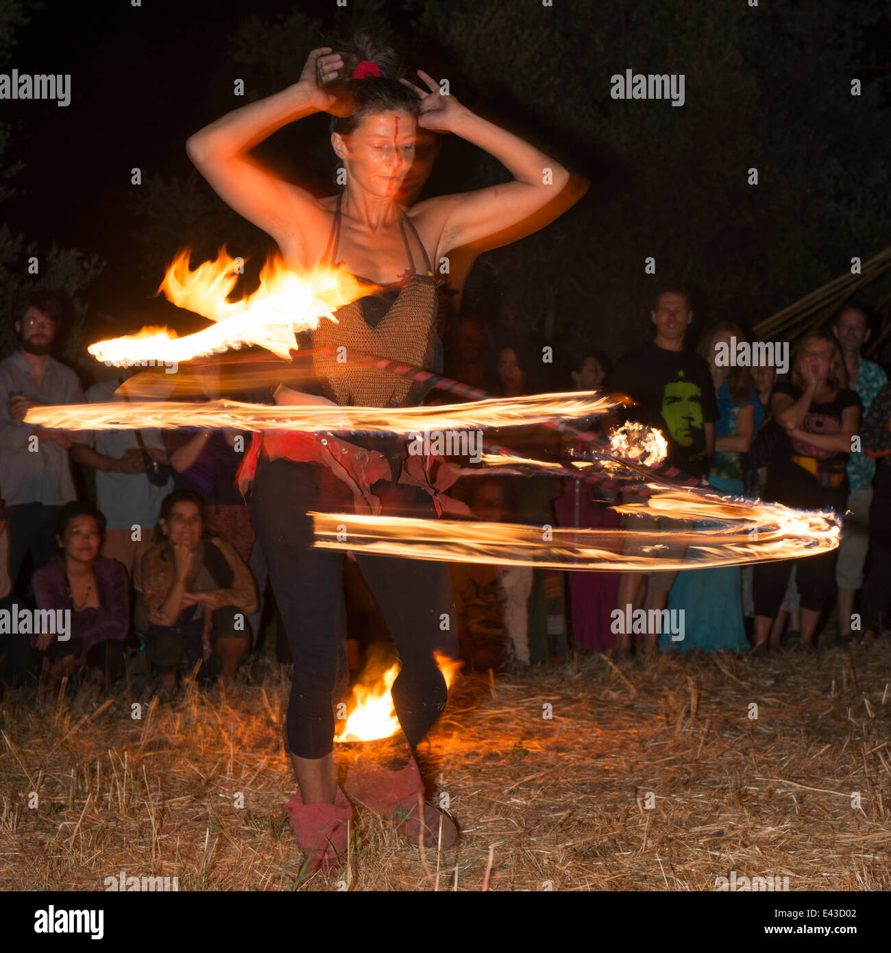Eine Darsteller wirbelt einen Hoola Hoop des Feuers bei einem Feuer Auftritt in Orgiva, Andalusien, Spanien Stockfoto