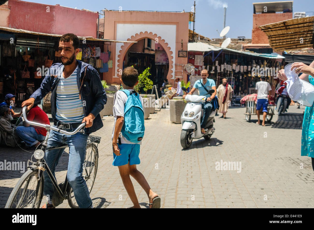 Reiten Fahrräder und Motorroller Vergangenheit der Eingang zum Souq, Marrakesch, Marokko. Stockfoto
