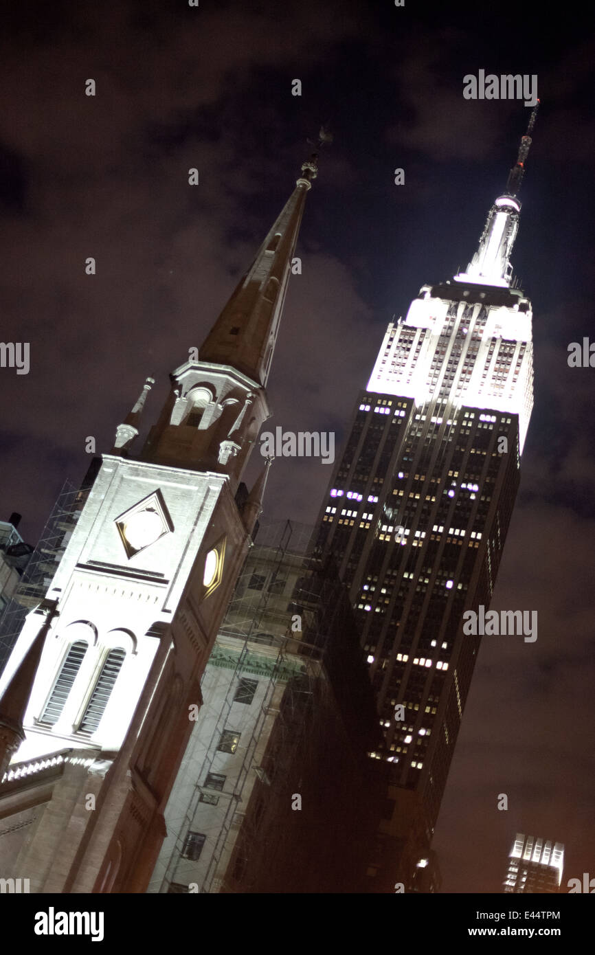 Empire State Building und Kirche in der Nacht Stockfoto