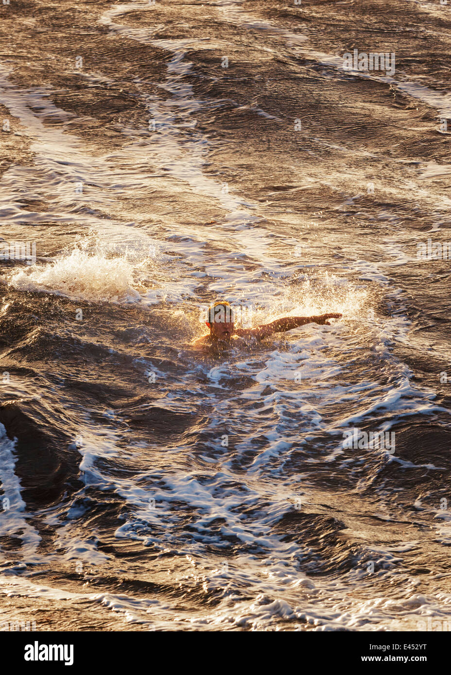 Mann in rauen Gewässern schwimmen. Stockfoto