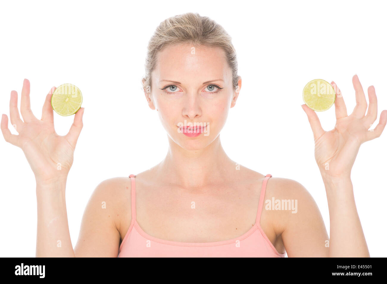 attraktive junge blonde Frau in rosa Weste Top hält Zitronenscheiben Kalk in die Augen Lächeln Stockfoto