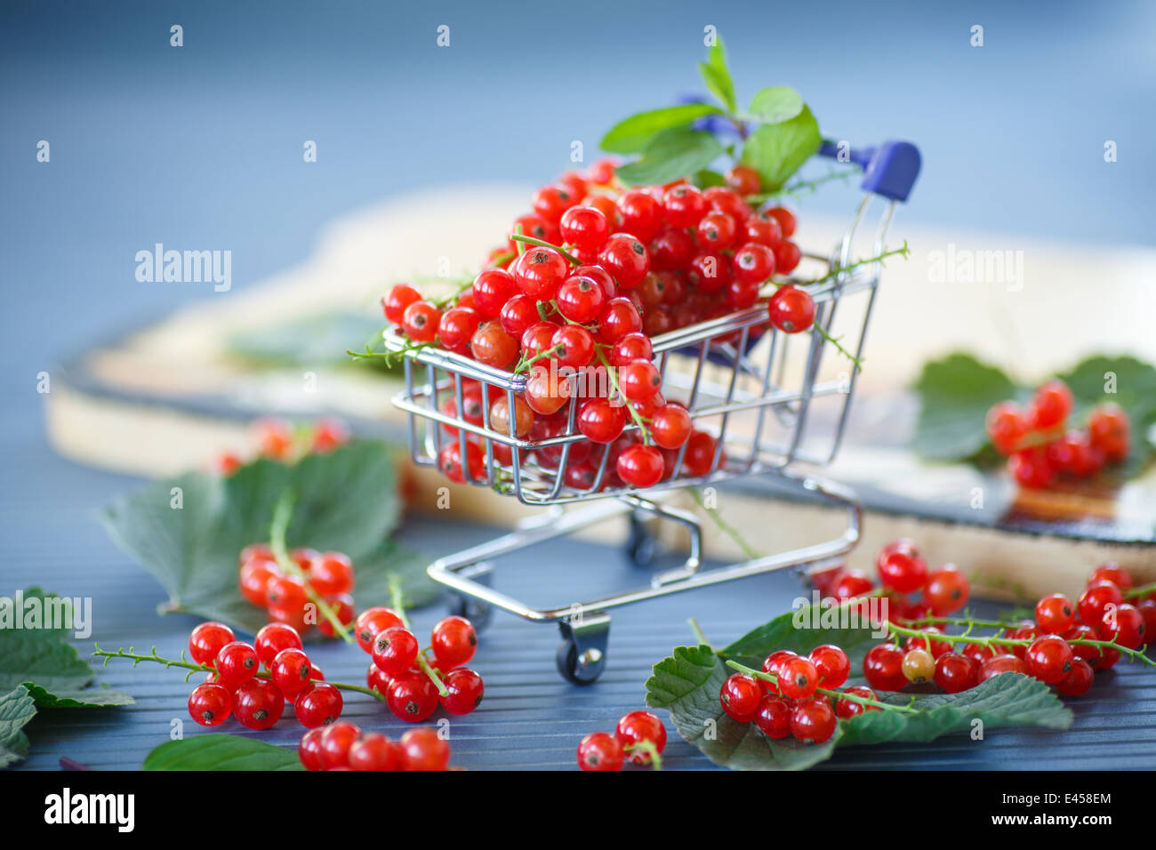 Reife rote Johannisbeeren in einem Korb auf einem Holztisch Stockfoto