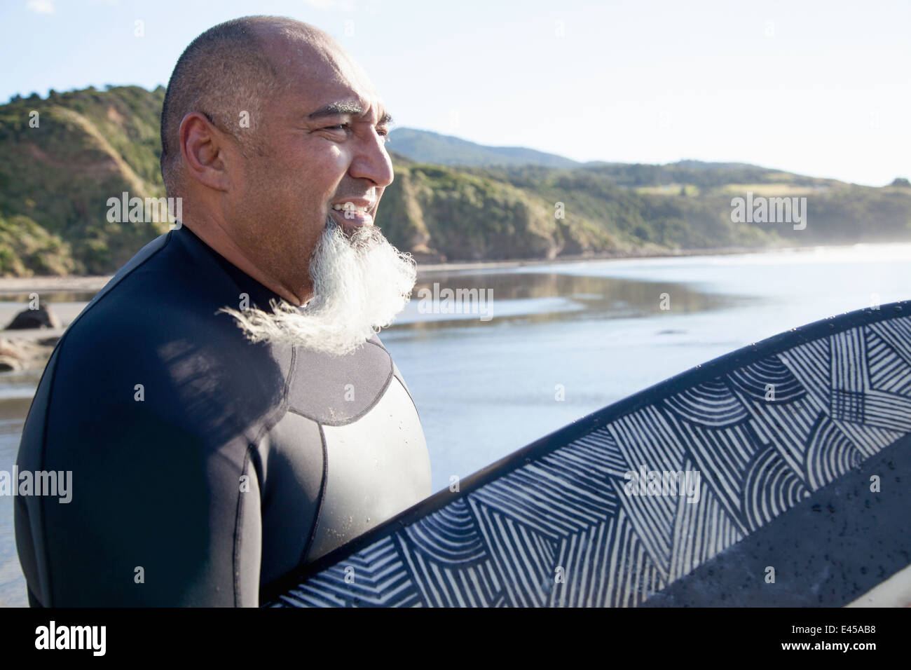 Ältere männliche Surfer mit Surfbrett Meer beobachten Stockfoto