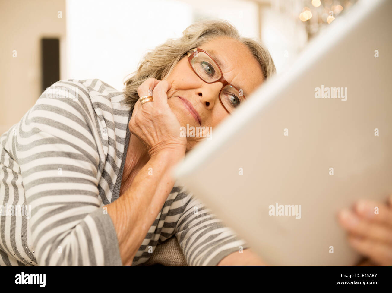 Ältere Frau liest mit digital-Tablette Stockfoto