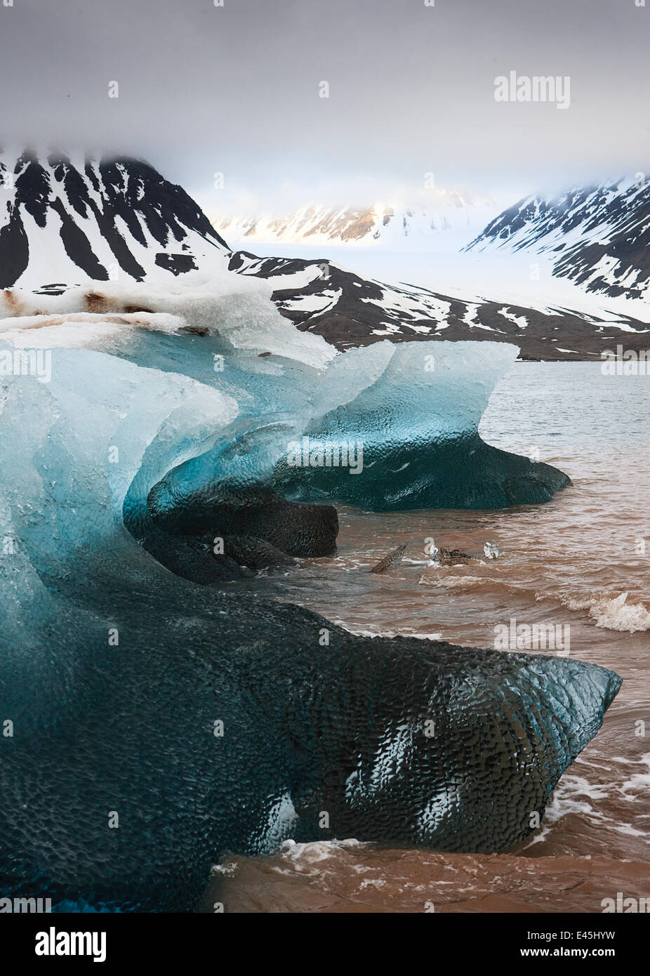 Eis an der Küste mit tief hängenden Wolken über Berge, Spitzbergen, Svalbard, Norwegen, Juni 2009 Stockfoto