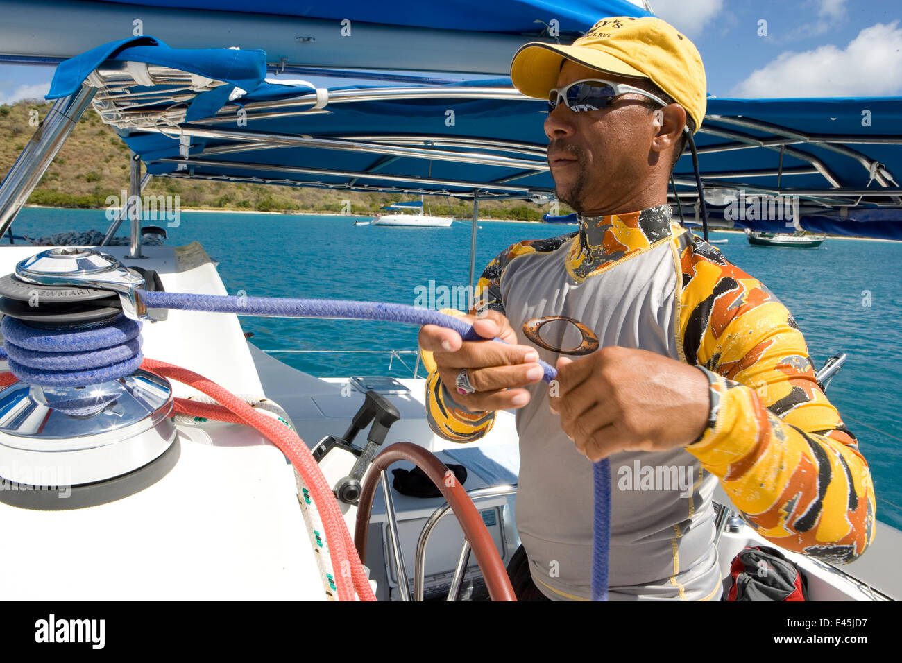 Mann Trimmen der Segel an Bord einer Sunsail Yacht in den British Virgin Islands, März 2006. Modell und der Eigenschaft freigegeben. Stockfoto