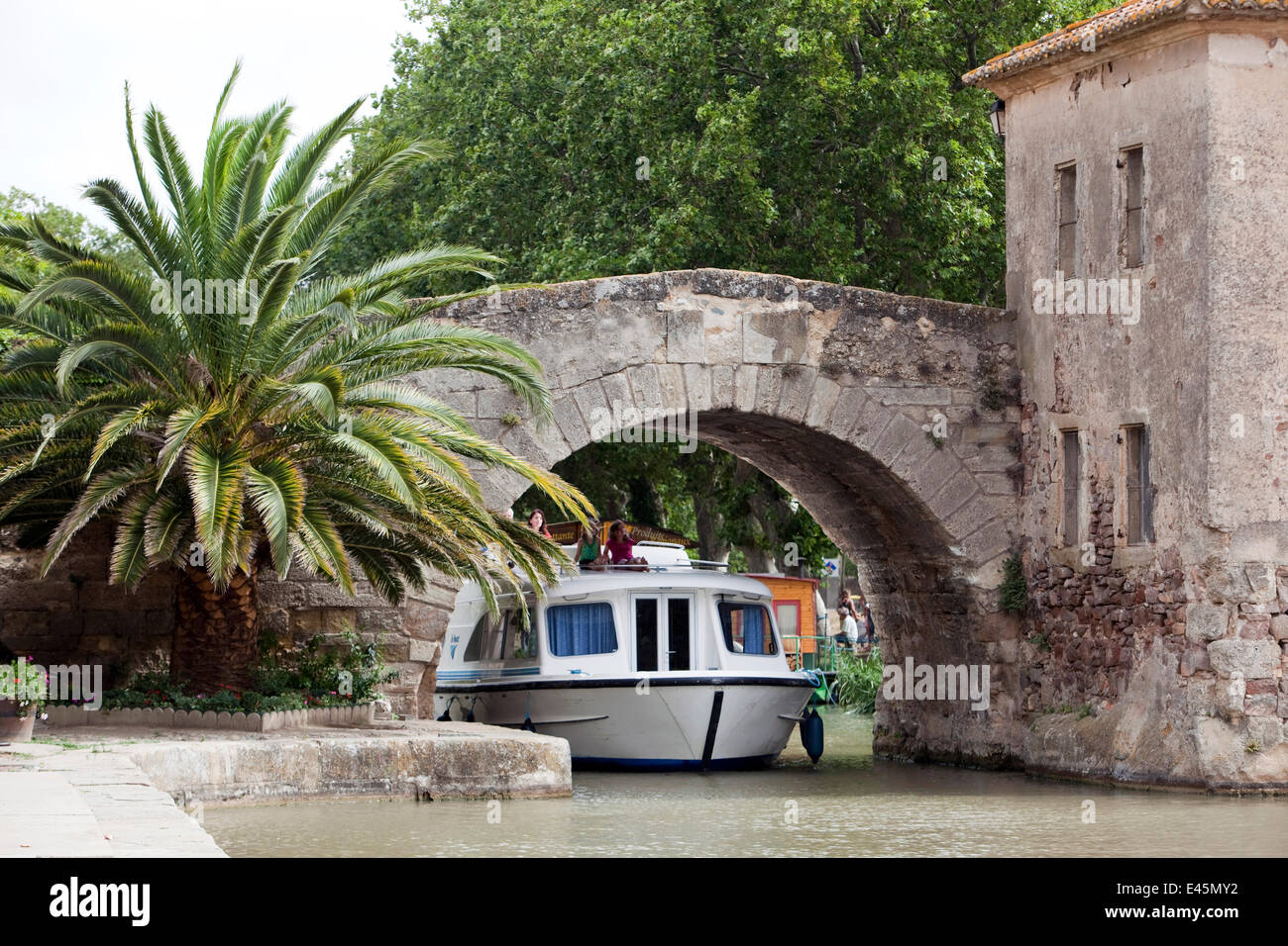 Boot unter einer Brücke über den Canal Du Midi, Le Somail, Frankreich vorbei. Juli 2009. -Modell veröffentlicht. Stockfoto