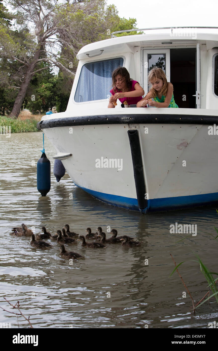 Mädchen Stockente Enten füttern, vom Bug eines Bootes, Kreuzfahrt auf dem Canal Du Midi in der Nähe von Capestang, Südfrankreich. Juli 2009. Modell und der Eigenschaft freigegeben. Stockfoto