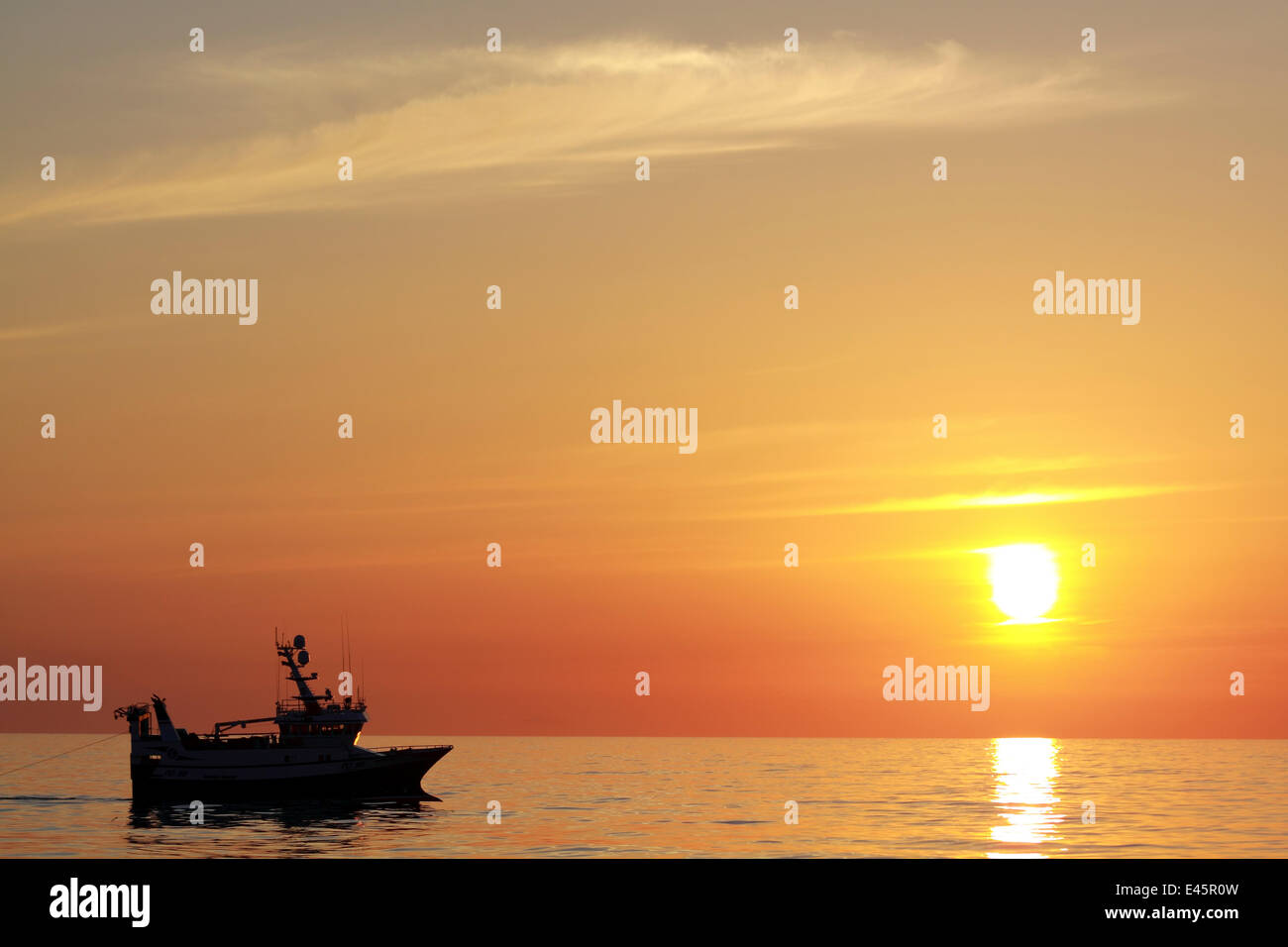 Schleppnetzfischerei an der Nordsee in Windstille bei Sonnenuntergang, Mai 2010. Eigentum freigegeben. Stockfoto