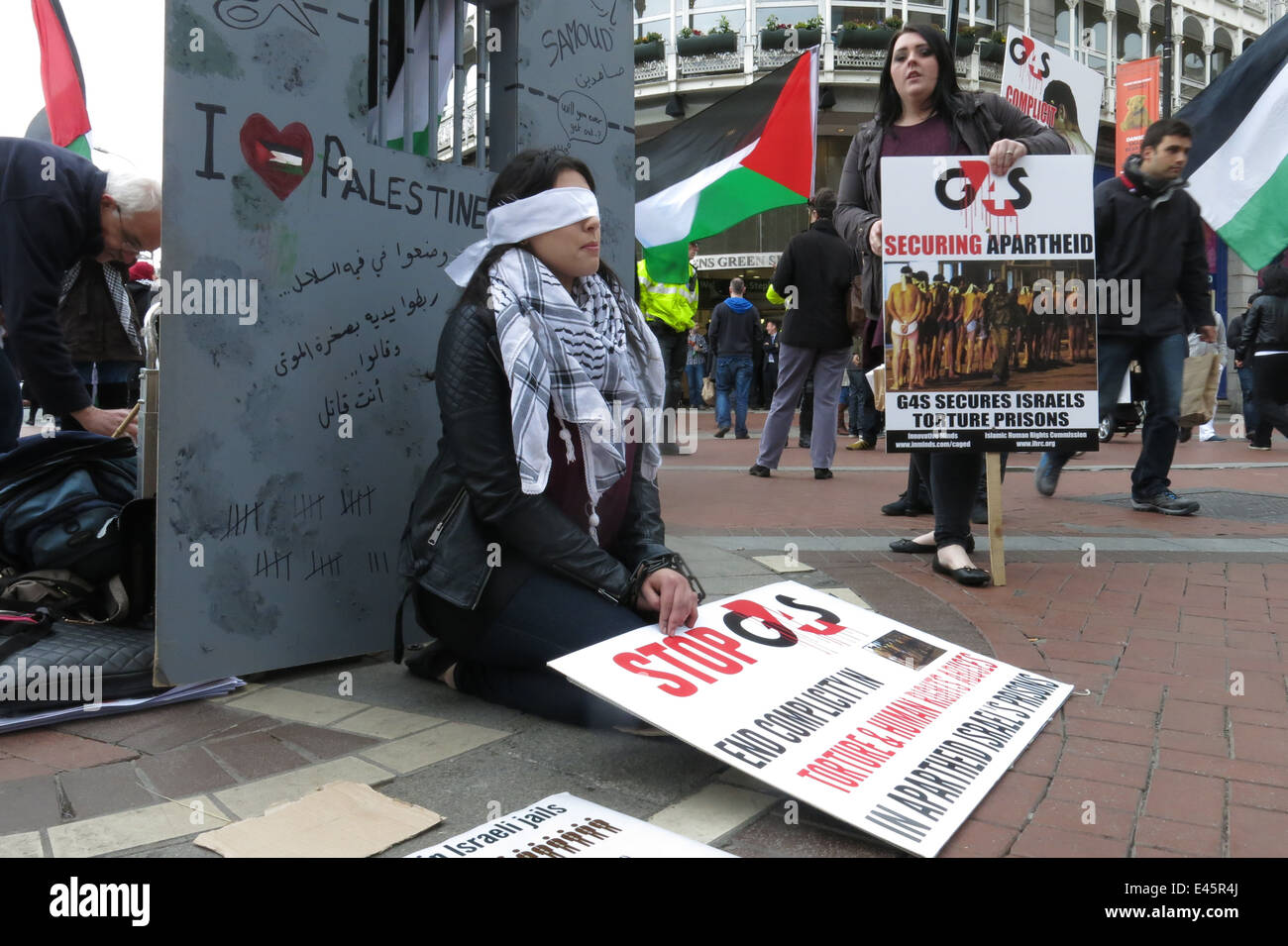 Nessrin Zavai in Handschellen und mit verbundenen Augen, zeigt auf einen Protest gegen private Sicherheitsfirma G4S durch das IPSC Stockfoto