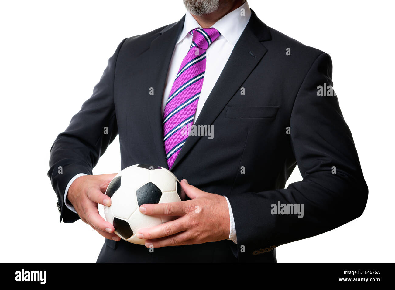 Business-Mann im dunklen Anzug und Krawatte hält einen Fußball Stockfoto