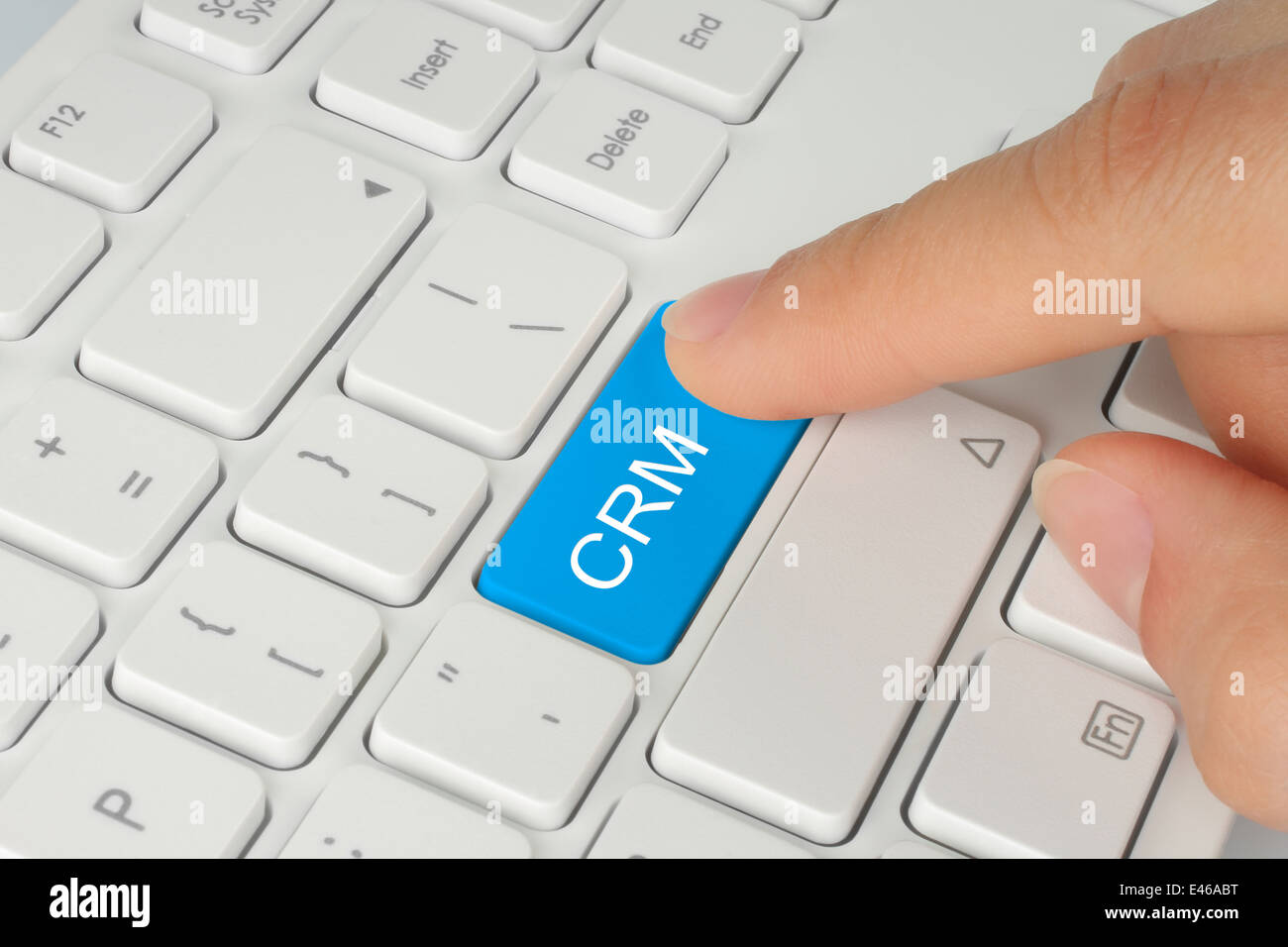 Hand drücken Blau CRM (Customer Relationship Management) Taste auf der Tastatur Weiß Hintergrund Stockfoto
