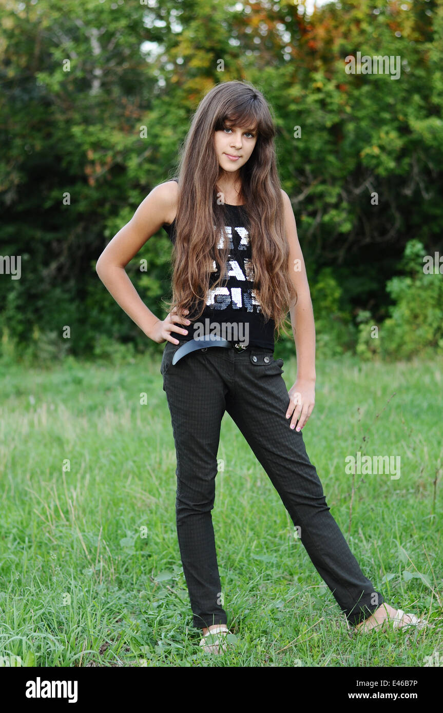 Mädchen Teen Teenager Übergang Alter 13 14 15 Jahre brünette Haare lange dunkle Natur Park Open-Air schönes Porträt stehen Shirt Stockfoto
