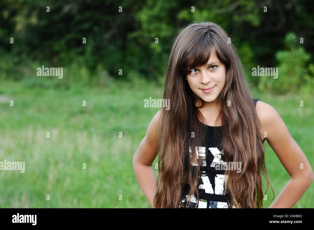 Mädchen Teen Teenager Übergang Alter 13 14 15 Jahre brünette Haare lange dunkle Natur Park Open-Air schönes Porträt stehen Shirt Stockfoto