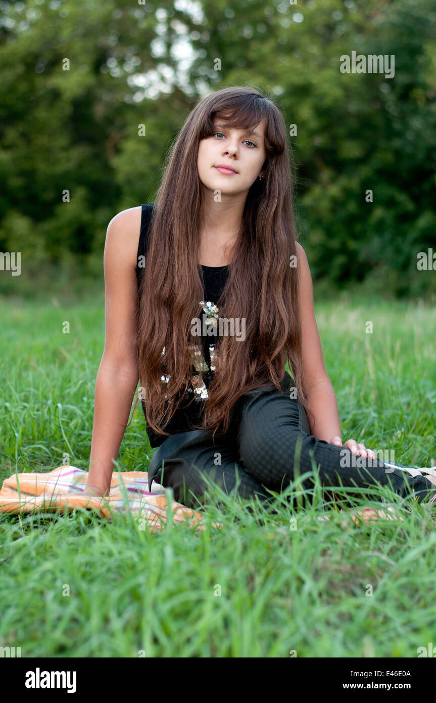 Mädchen Teen Teenager Übergang Alter 13 14 15 Jahre brünette Haare lange dunkle Natur Park Open-Air schönes Porträt stehen Shirt Stockfoto