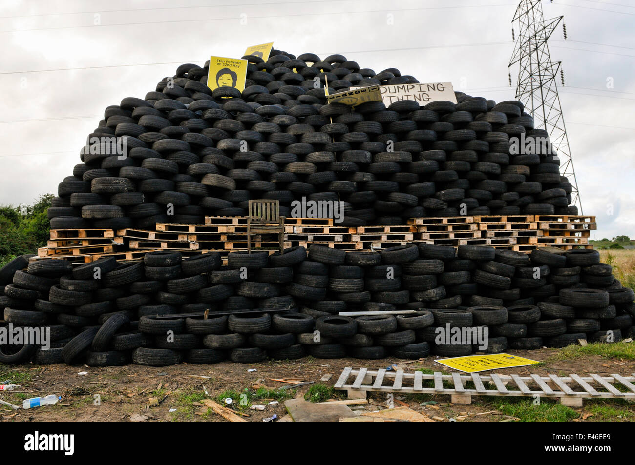 Carrickfergus, Nordirland. 3. Juli 2014 - ein illegales Lagerfeuer wurde hauptsächlich aus Reifen gebaut. Die enorme Struktur enthält schätzungsweise 5.000 Reifen, die alle von den Reifenhändlern umweltfreundlich hätten entsorgt werden müssen. Es wurde mit Fotos von Anna Lo von der Allianzpartei geschmückt, die Loyalisten für die Entfernung der Unionsflagge aus dem Rathaus von Belfast verantwortlich gemacht haben. Diese Struktur wird am 11. Juli in Brand gesetzt, was zu Problemen für die Menschen in dem Bereich führen wird, in dem es zu Problemen mit der Niederlassung kommt. Kredit: Stephen Barnes/Alamy Live News Stockfoto