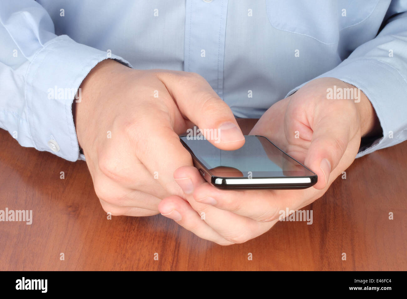 Geschäftsmann berühren Smart Phone am Tisch Stockfoto