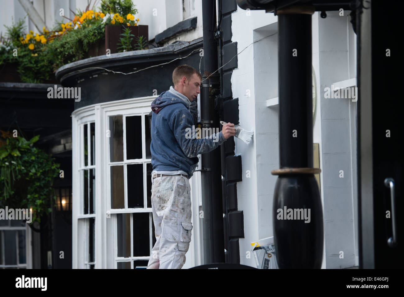 Ein Mann, der Malerei ein Haus, UK Stockfoto