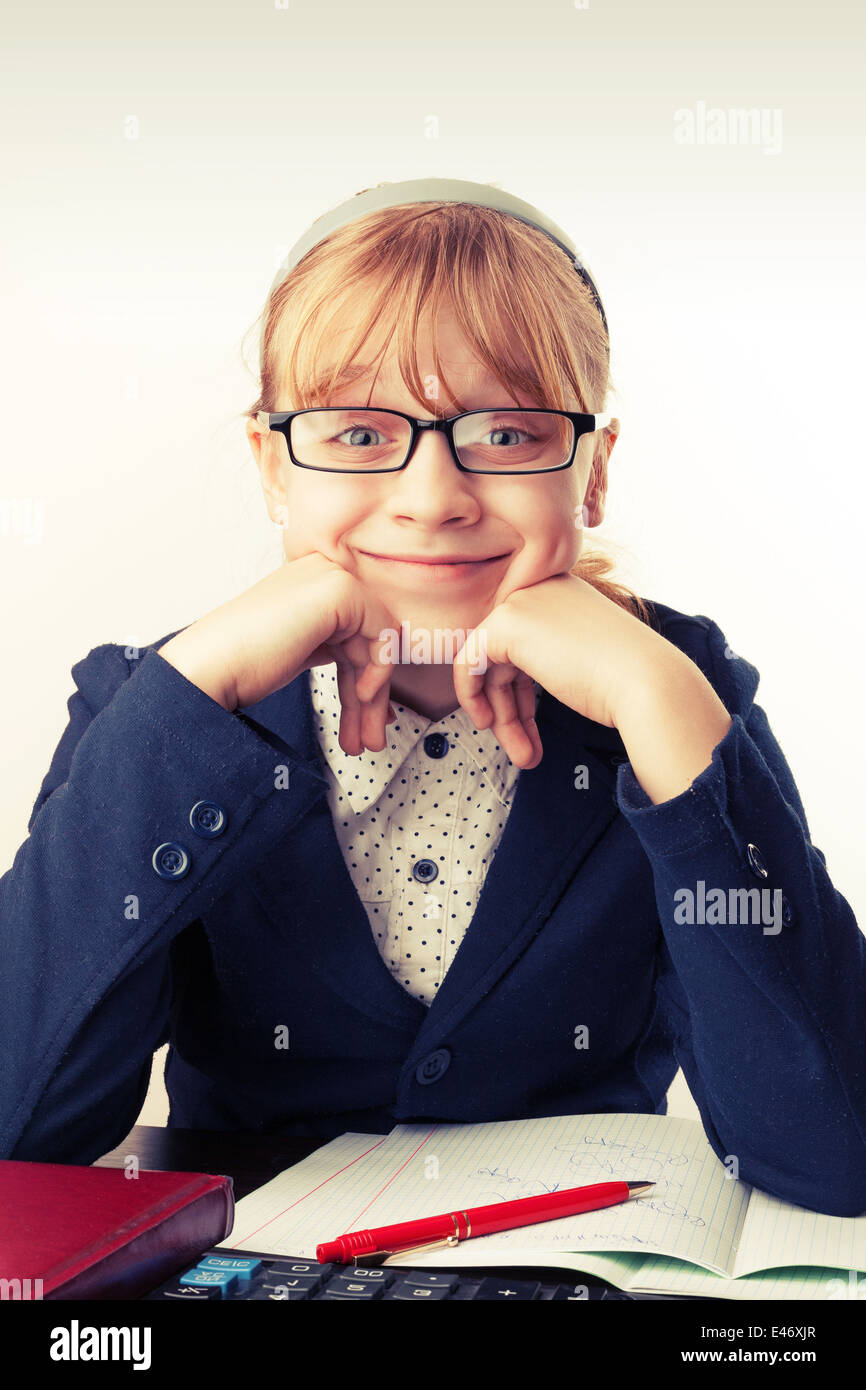 Kleines blondes Schulmädchen mit Brille lächelt über weiß. Getönten Effekt Stockfoto