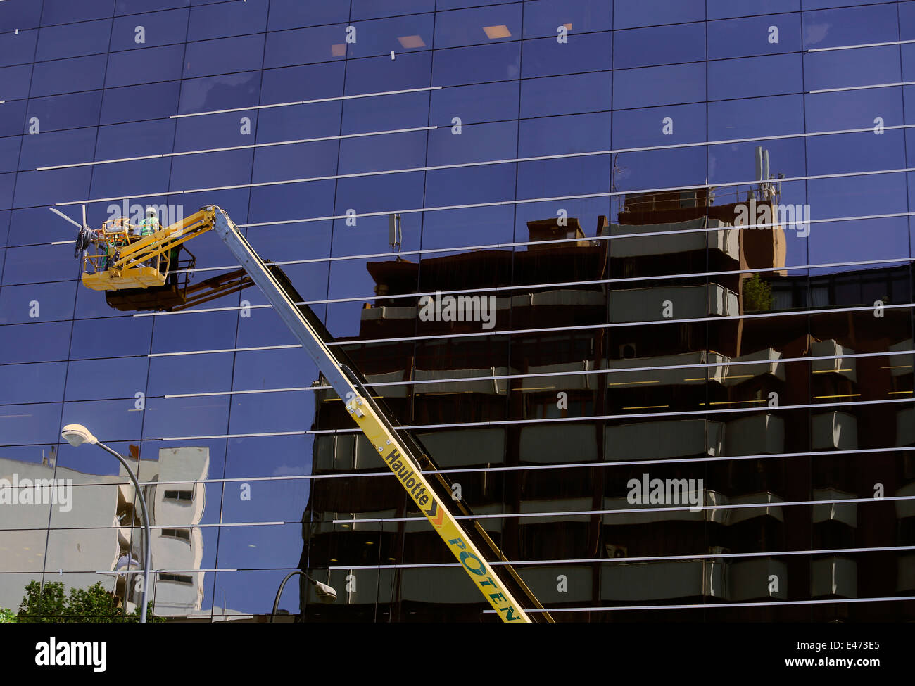 Ein Fenster Reinigung team gesehen arbeiten über unteren Ebenen auf einem Wolkenkratzer in Mallorca Stockfoto